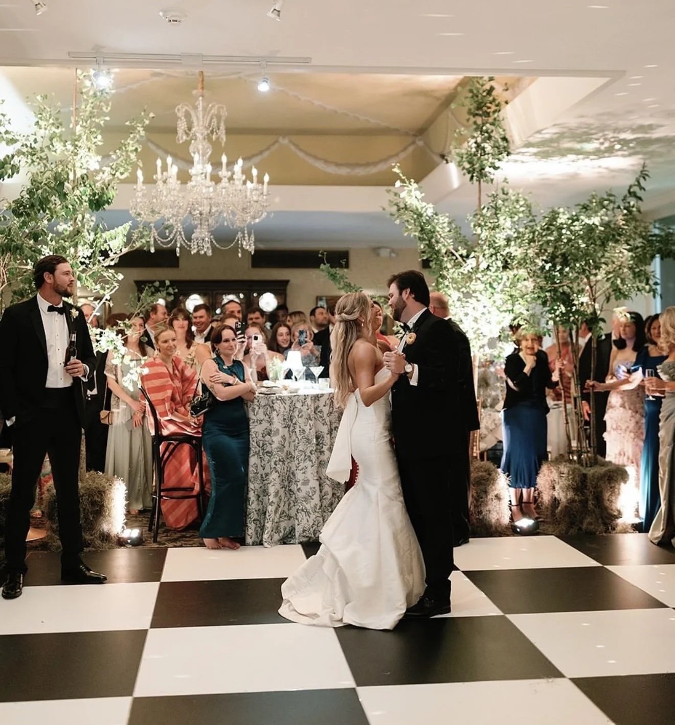 Checkerboard dance floor set up under a clear tent at an outdoor New Orleans wedding reception