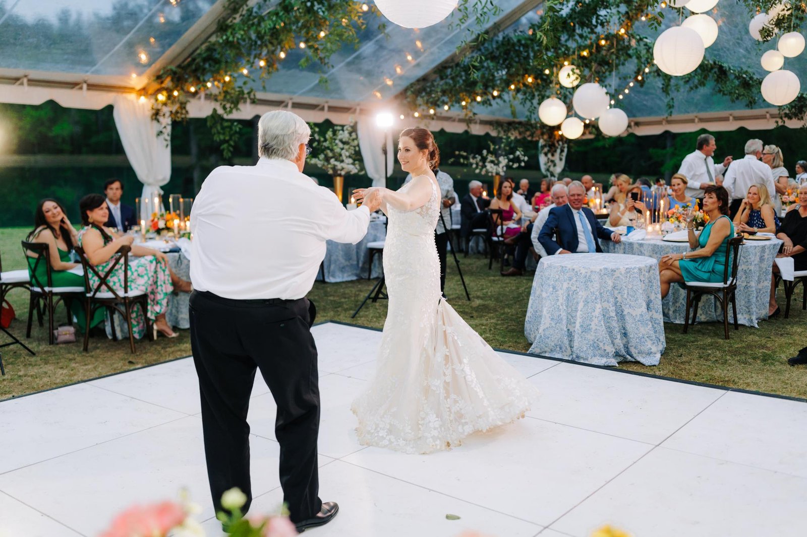 Couple's first dance on a checkerboard patterned dance floor under a tent at a New Orleans reception